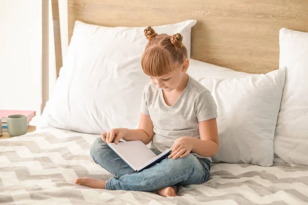 Cute little girl reading book at home — Stock Photo, Image