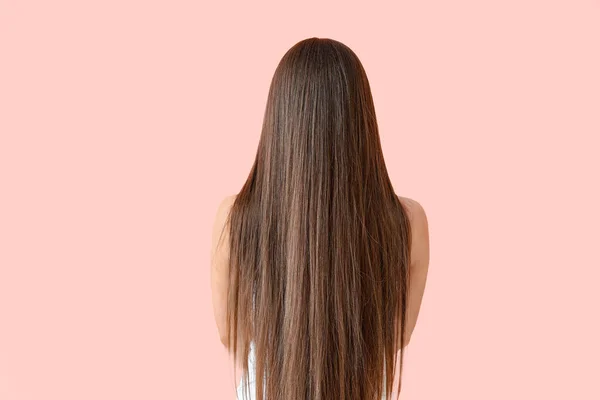 Belle femme avec des cheveux longs sains sur fond de couleur, vue de dos — Photo