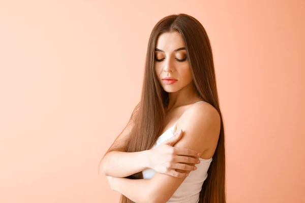 Gyönyörű nő egészséges hosszú haj színes háttér — Stock Fotó
