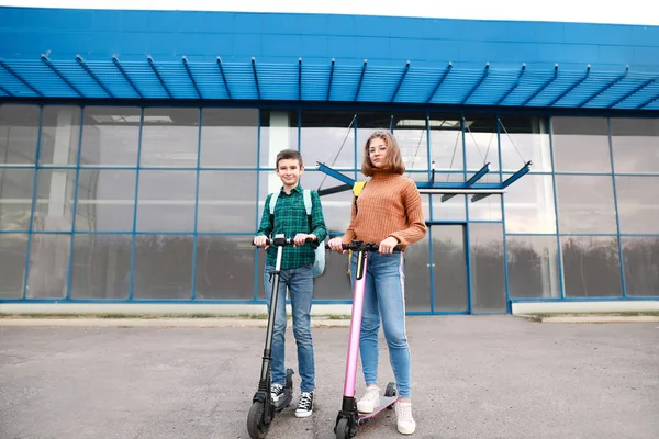 Active teenagers riding kick scooters outdoors — 스톡 사진
