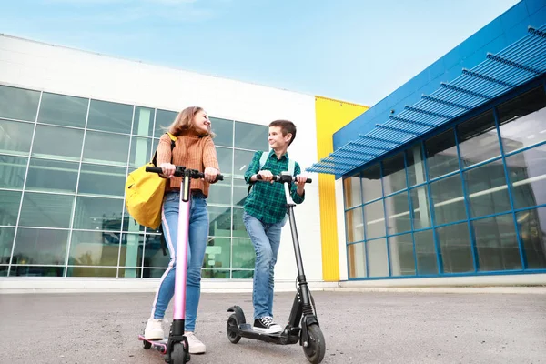 Active teenagers riding kick scooters outdoors — 스톡 사진