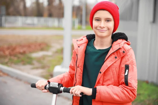 Teenage boy riding kick scooter outdoors — Stock Photo, Image