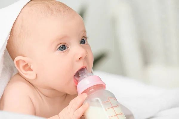 Portrait of cute little baby drinking milk from bottle on bed — Stock Photo, Image