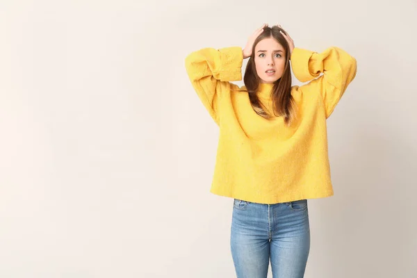 Mujer joven estresada sobre fondo claro. Concepto de elección — Foto de Stock