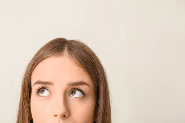 Thoughtful young woman on light background. Concept of choice — Stock Photo, Image