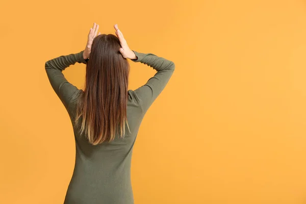 Stressed young woman on color background, back view. Concept of choice — Stock Photo, Image