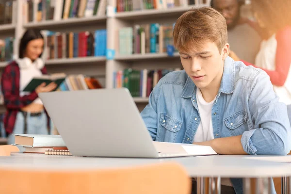 Estudante do sexo masculino se preparando para exame na biblioteca — Fotografia de Stock