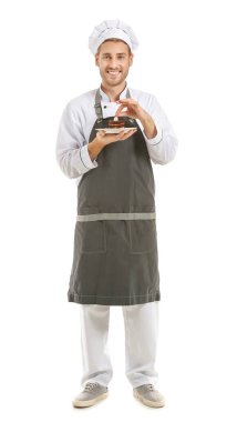 Beyaz arka planda kek dilimi olan mutlu erkek aşçı.