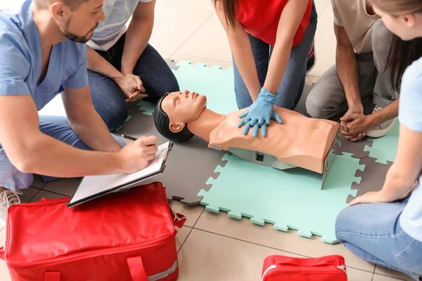 Instructor demonstrating CPR on mannequin at first aid training course — Stock Photo, Image