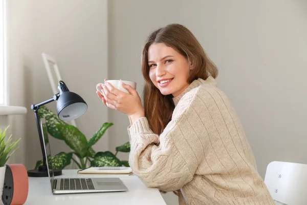 Młoda kobieta pije herbatę w biurze — Zdjęcie stockowe