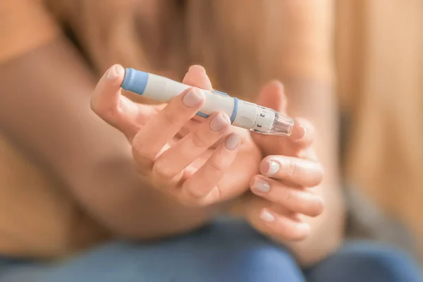 Diabetic woman taking blood sample with lancet pen at home, closeup — Stock Photo, Image