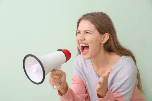 Young woman with megaphone on color background — Stock Photo, Image