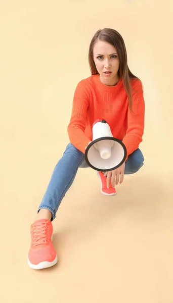 Young woman with megaphone on color background — Stock Photo, Image