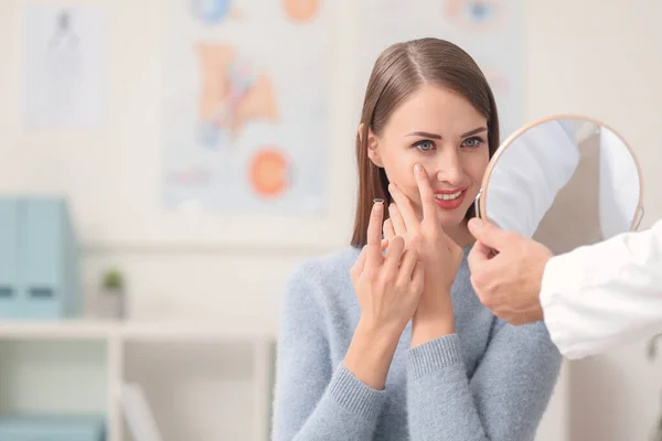 Mujer poniendo lentes de contacto en los ojos en el consultorio del oftalmólogo — Foto de Stock