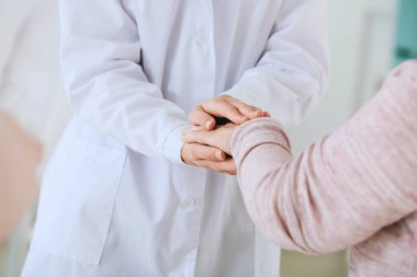 Klinikte Parkinson sendromu olan yaşlı bir kadın doktor.