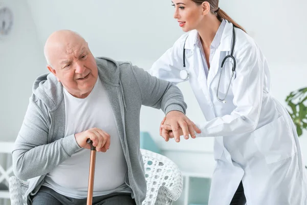 Female doctor with senior man suffering from Parkinson syndrome in clinic — Stock Photo, Image