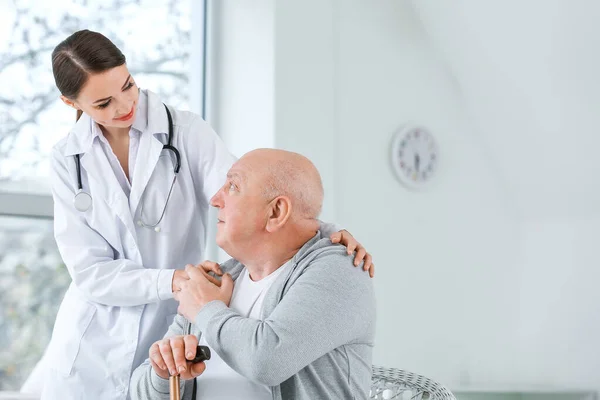 Medico femminile con uomo anziano affetto da sindrome di Parkinson in clinica — Foto Stock