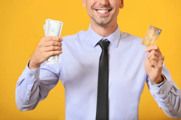 Чоловічий менеджер банку з кредитною карткою та грошима на кольоровому фоні — стокове фото