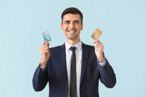 Male bank manager with credit cards on light background — Stock Photo, Image