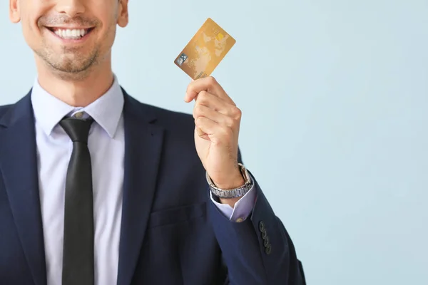 Male bank manager with credit card on light background — Stock Photo, Image