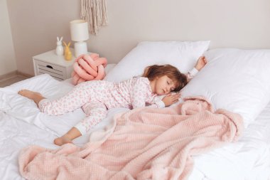 Yatakta uyuyan tatlı küçük kız.
