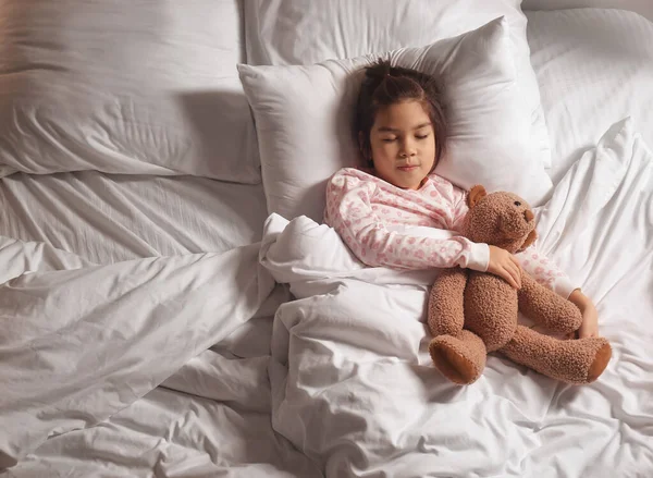 Küçük tatlı Asyalı kız yatakta uyuyor. — Stok fotoğraf