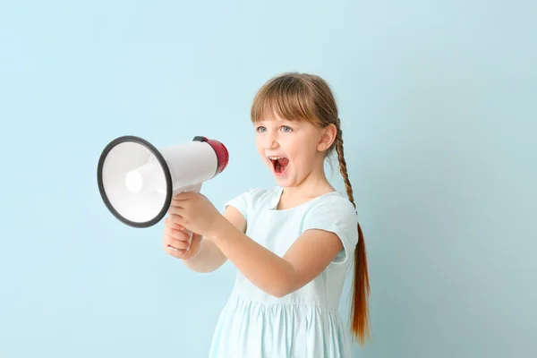 Nettes kleines Mädchen mit Megafon auf farbigem Hintergrund — Stockfoto