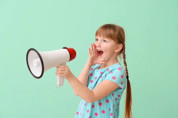 Nettes kleines Mädchen mit Megafon auf farbigem Hintergrund — Stockfoto