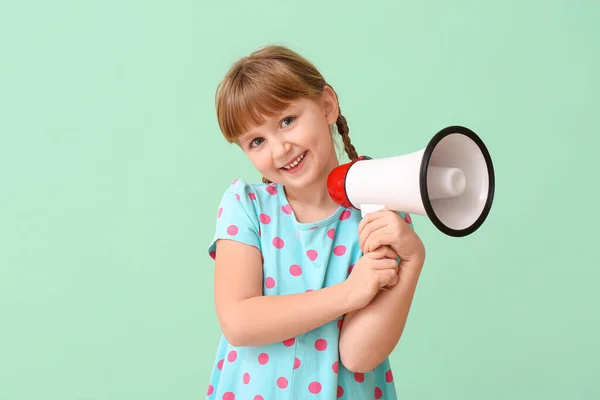 Милая маленькая девочка с мегафоном на цветном фоне — стоковое фото