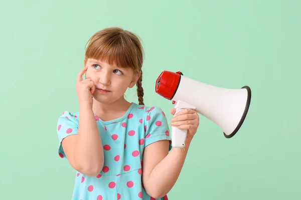 Thoughtful little girl with megaphone on color background — Stock Photo, Image