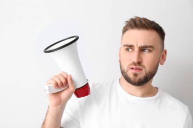 Hafif arka planda megafonu olan duygusal genç bir adam.