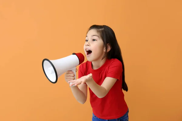 Nettes kleines Mädchen mit Megafon auf farbigem Hintergrund — Stockfoto