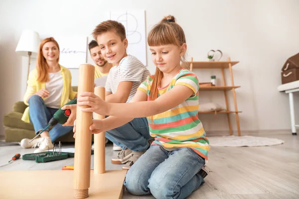 Family assembling furniture at home — Stock Photo, Image