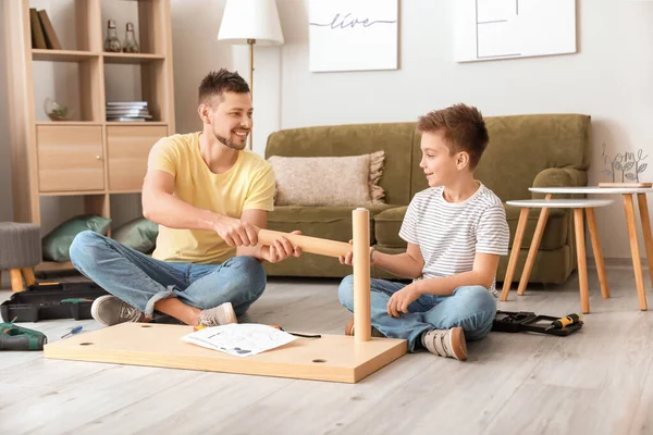 Father and his little son assembling furniture at home — Stock Photo, Image