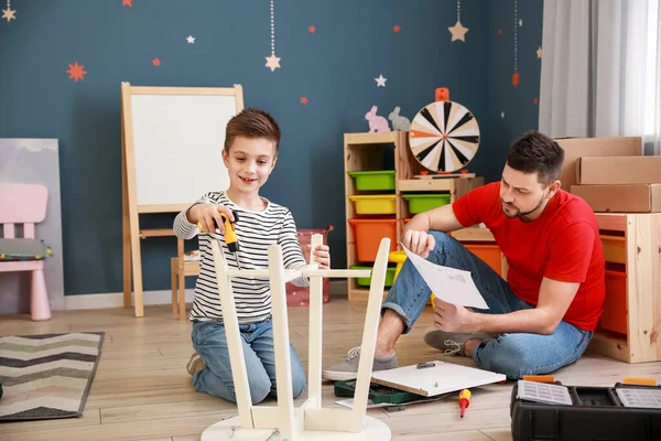 Father and his little son assembling furniture at home — Stock Photo, Image