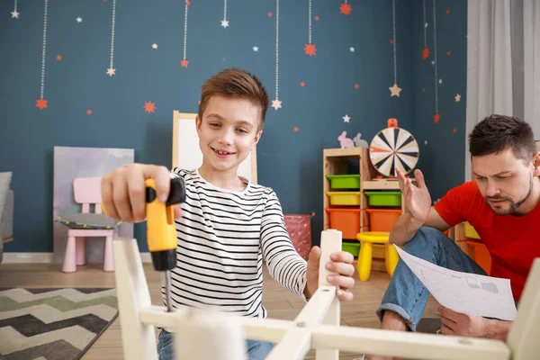 Father and his little son assembling furniture at home — Stock Photo, Image