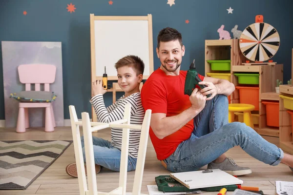 Babası ve küçük oğlu evde mobilya montajı yapıyor. — Stok fotoğraf
