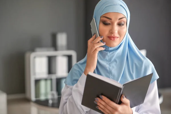 Fiatal arab nő beszél telefonon az irodában — Stock Fotó