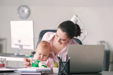 Annesi ve bebeği ofiste çalışıyor.