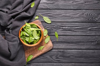 Koyu ahşap arka planda taze ıspanaklı kase.