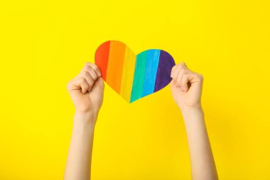 Renkli arka planda gökkuşağı kalpli bir kadın eli. Lgbt kavramı