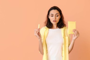 Regl pedi ve arka planda tamponu olan genç bir kadın.