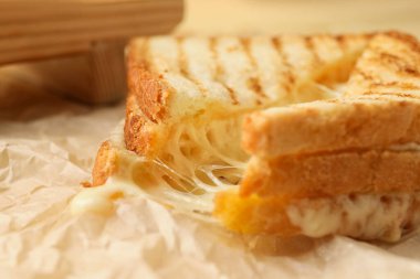 Tasty sandwiches with cheese on table, closeup