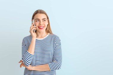 Güzel, genç bir kadın telefonda konuşuyor.