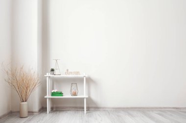 Shelf unit with decor near light wall