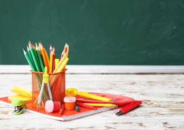 Sınıftaki masanın üzerinde okul kırtasiyesi var.