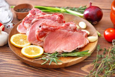 Ahşap zeminde çiğ domuz eti tabağı.