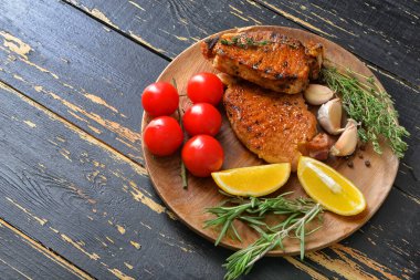 Koyu ahşap arka planda pişmiş domuz bifteği tabağı