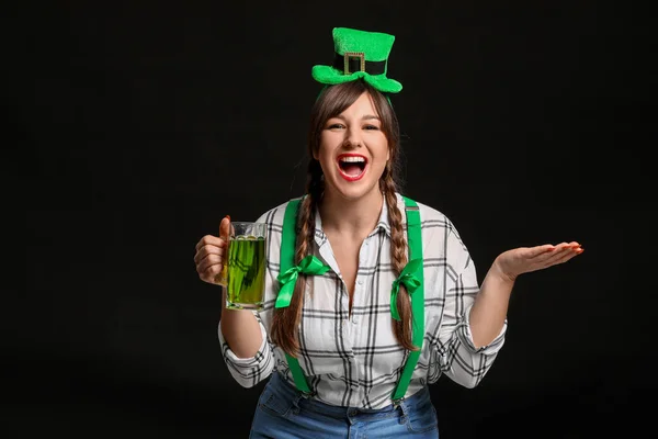 Vicces fiatal nő sörrel a sötét háttérben. Szent Patrik napi ünnepség — Stock Fotó