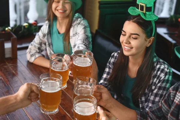 Jeunes amis avec de la bière célébrant la Saint-Patrick au pub — Photo